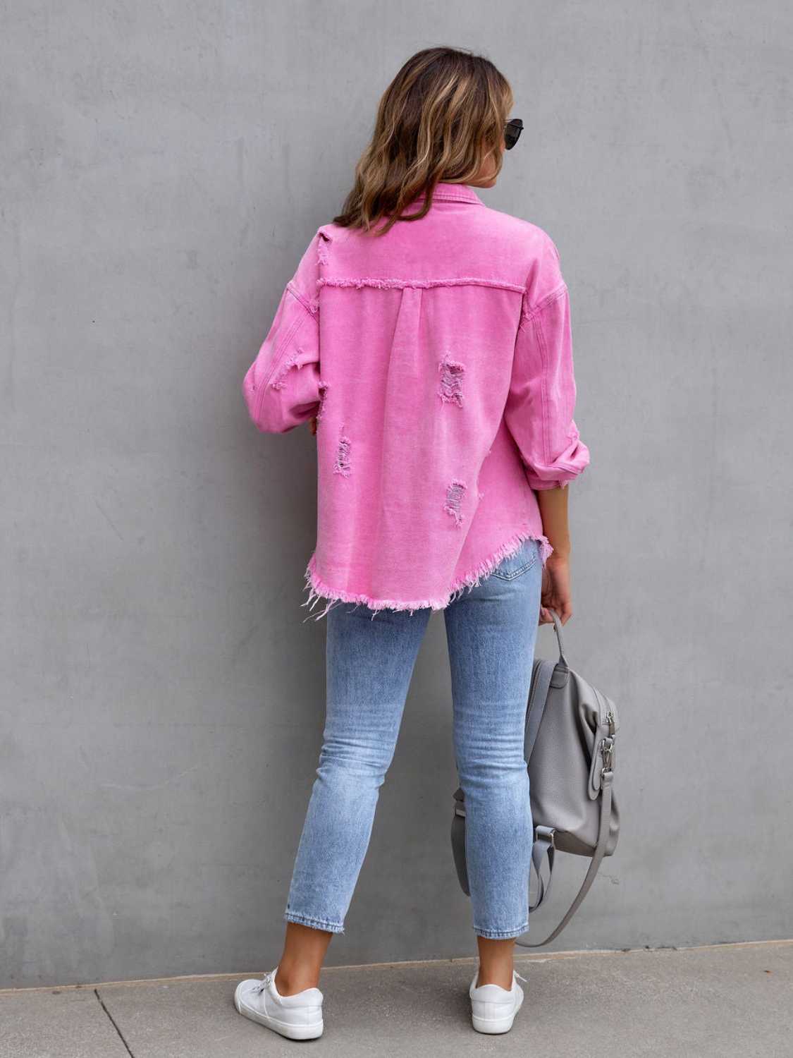 Back view of a pink distressed drop shoulder denim jacket with fringe hem and ripped details.