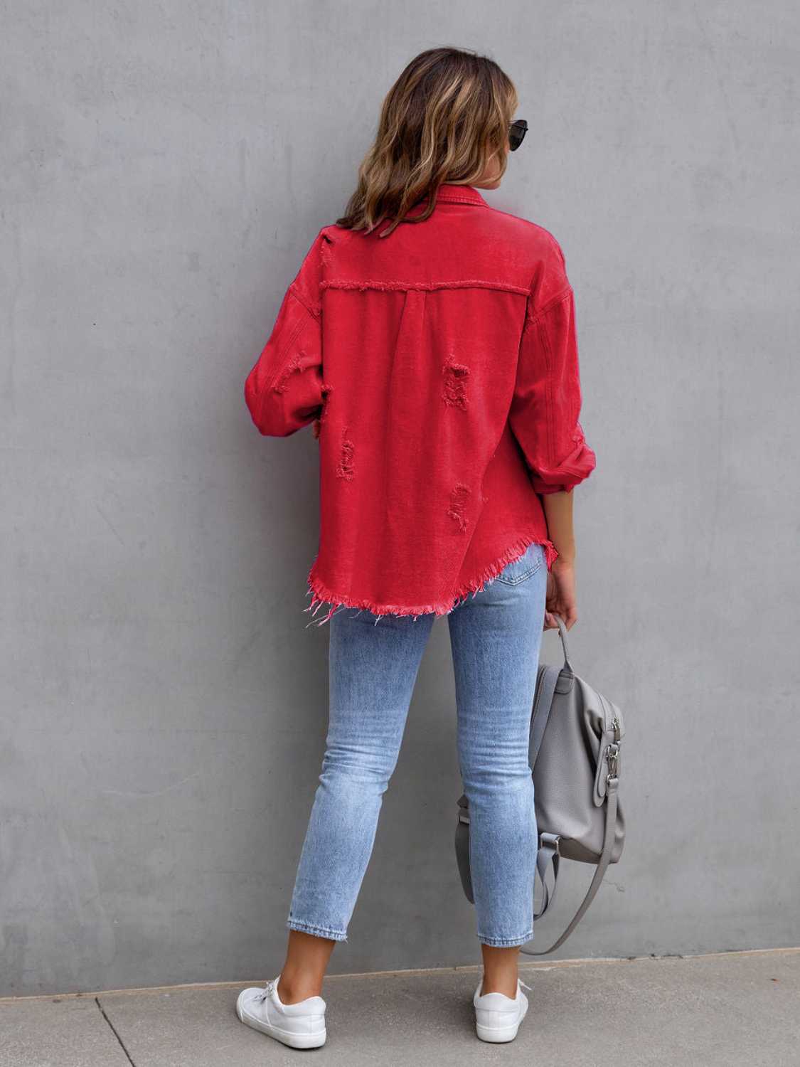 Back view of a red distressed drop shoulder denim jacket with fringe hem and ripped details.