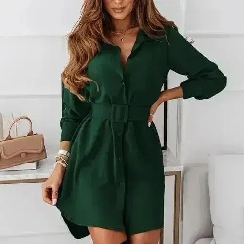 Woman wearing a dark green A-line shirt dress with a belt and collar.