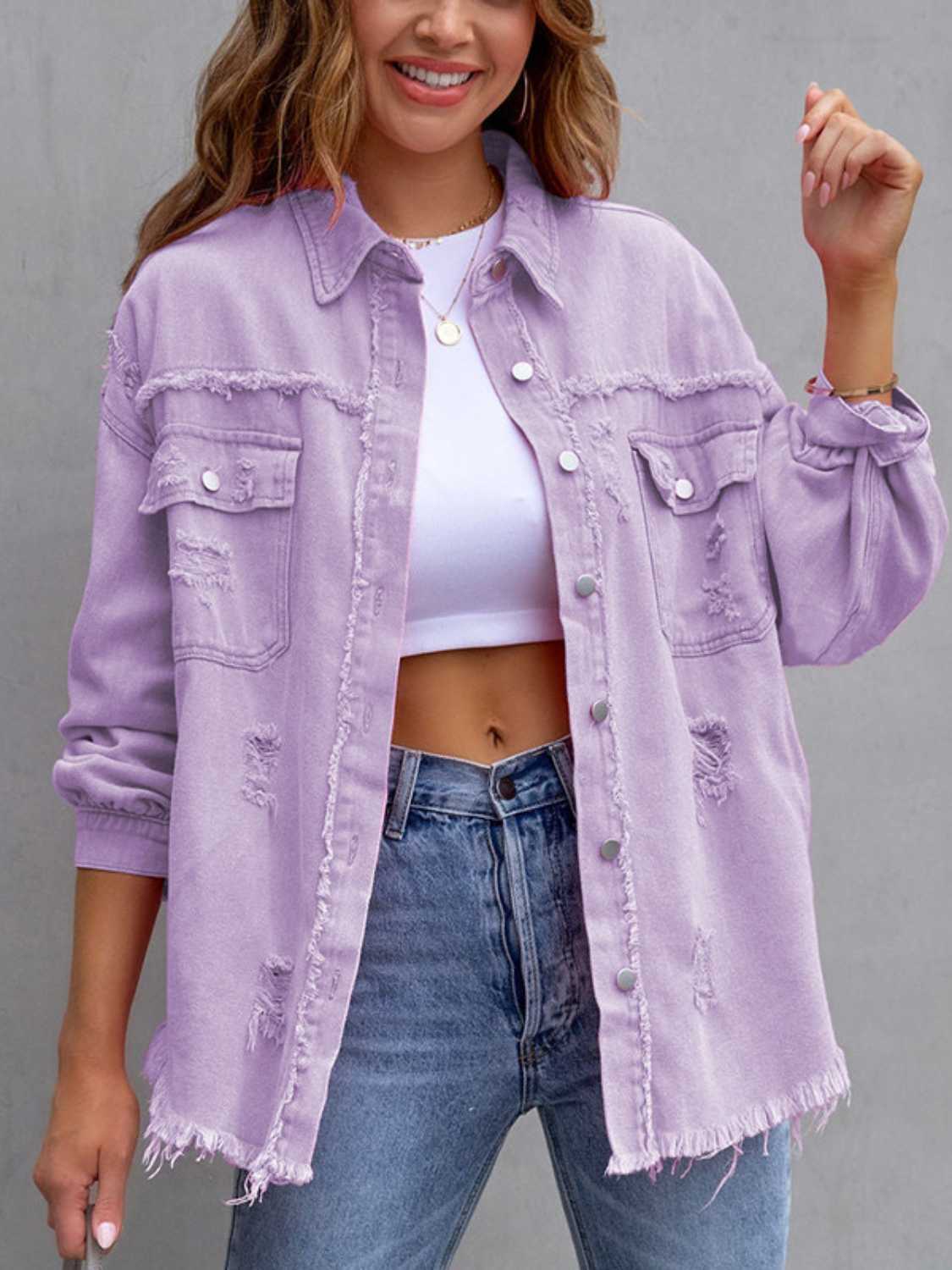 Woman wearing a light purple distressed drop shoulder denim jacket with fringe hem and raw edges.