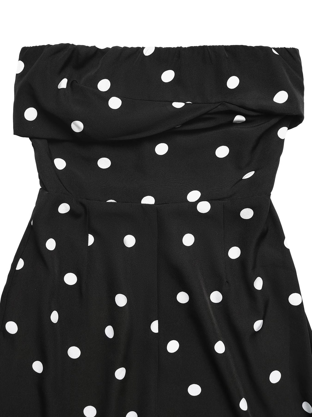 Close-up of a black strapless jumpsuit with a white polka dot pattern and a ruffled neckline.