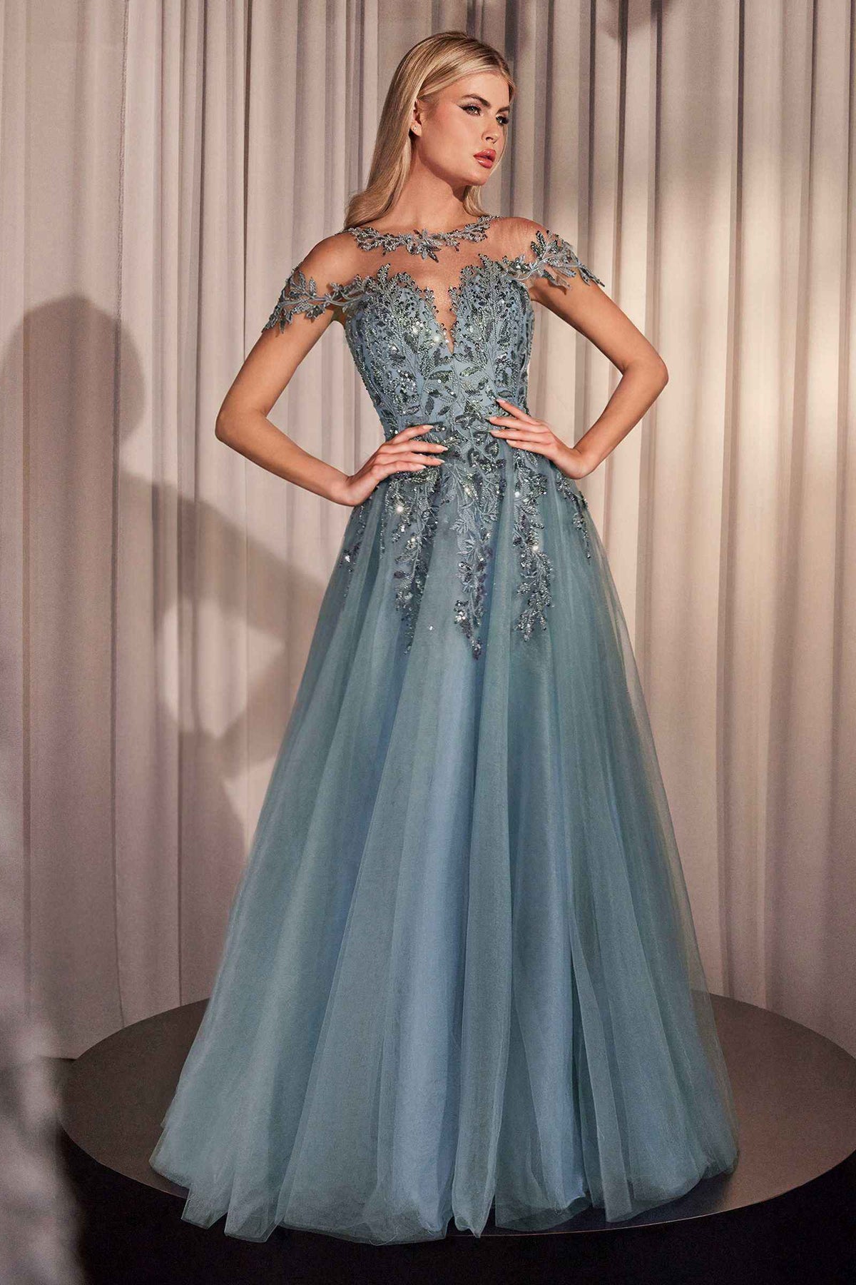 Dusty blue tulle A-line gown with cap sleeves, illusion neckline, and floral sequin appliqué.