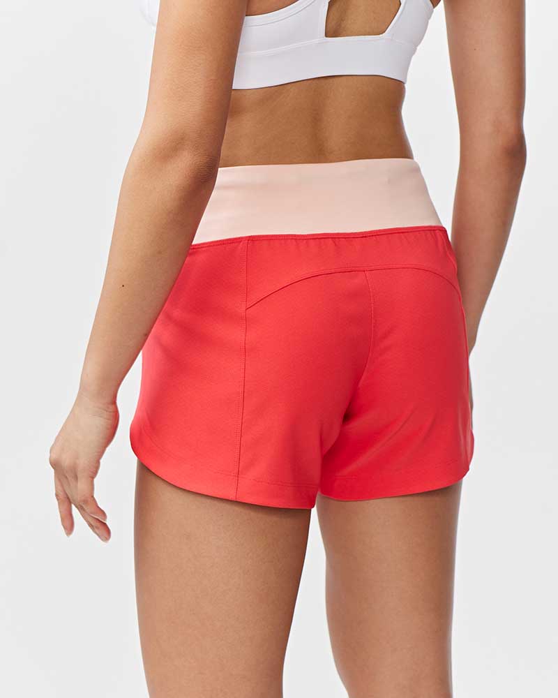 Back view of Goal Five Excel Women's Workout Shorts in hot coral with a light pink waistband.