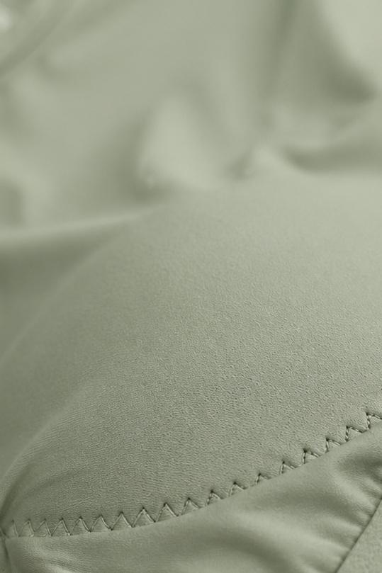 Close-up of a sage green Alyth Active GRAVITY Catalyst V2 sports bra showing fabric texture and stitching.