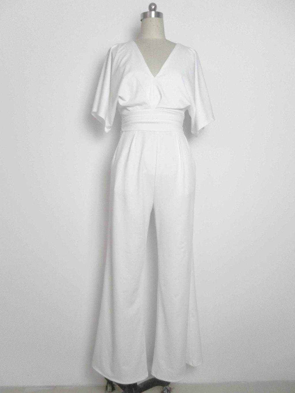 White wide-leg jumpsuit with a deep V-neck and a cinched waist, displayed on a mannequin.