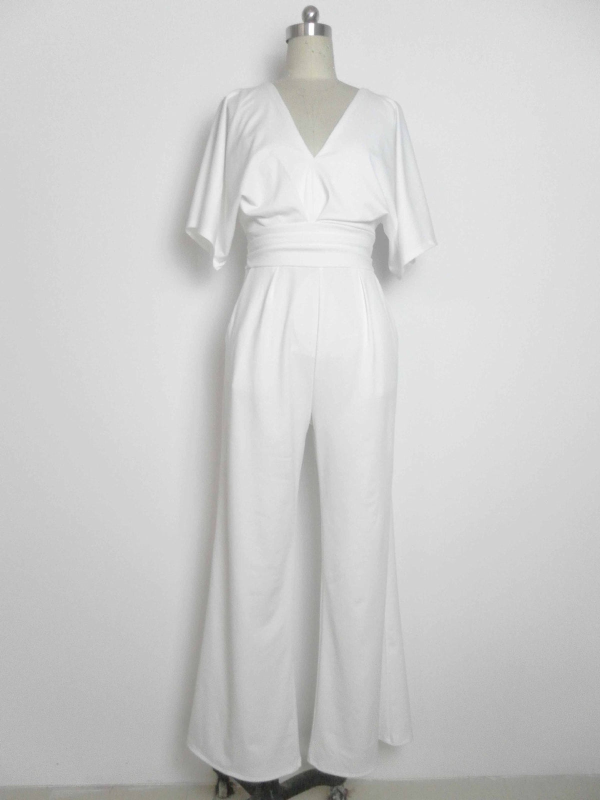 White wide-leg jumpsuit with a deep V-neck and a cinched waist, displayed on a mannequin.