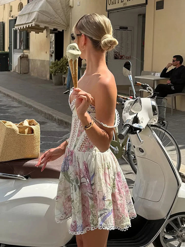 Woman in a floral V-neck lace hollow out A-line dress with spaghetti straps holding an ice cream.