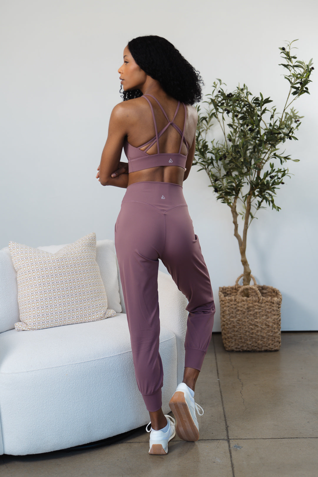 Back view of a woman wearing a dark mauve GRAVITY adventurous V2 sports bra with strappy back.