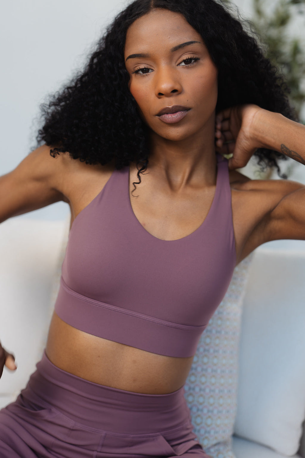 A woman wearing the GRAVITY adventurous V2 sports bra in umber with a V-neckline and sewn-in cups.
