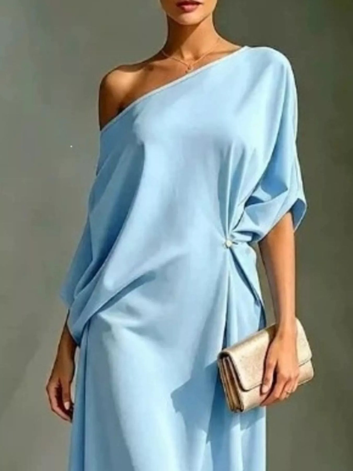 Plus size light blue asymmetrical one-shoulder drape dress with a gold clutch.