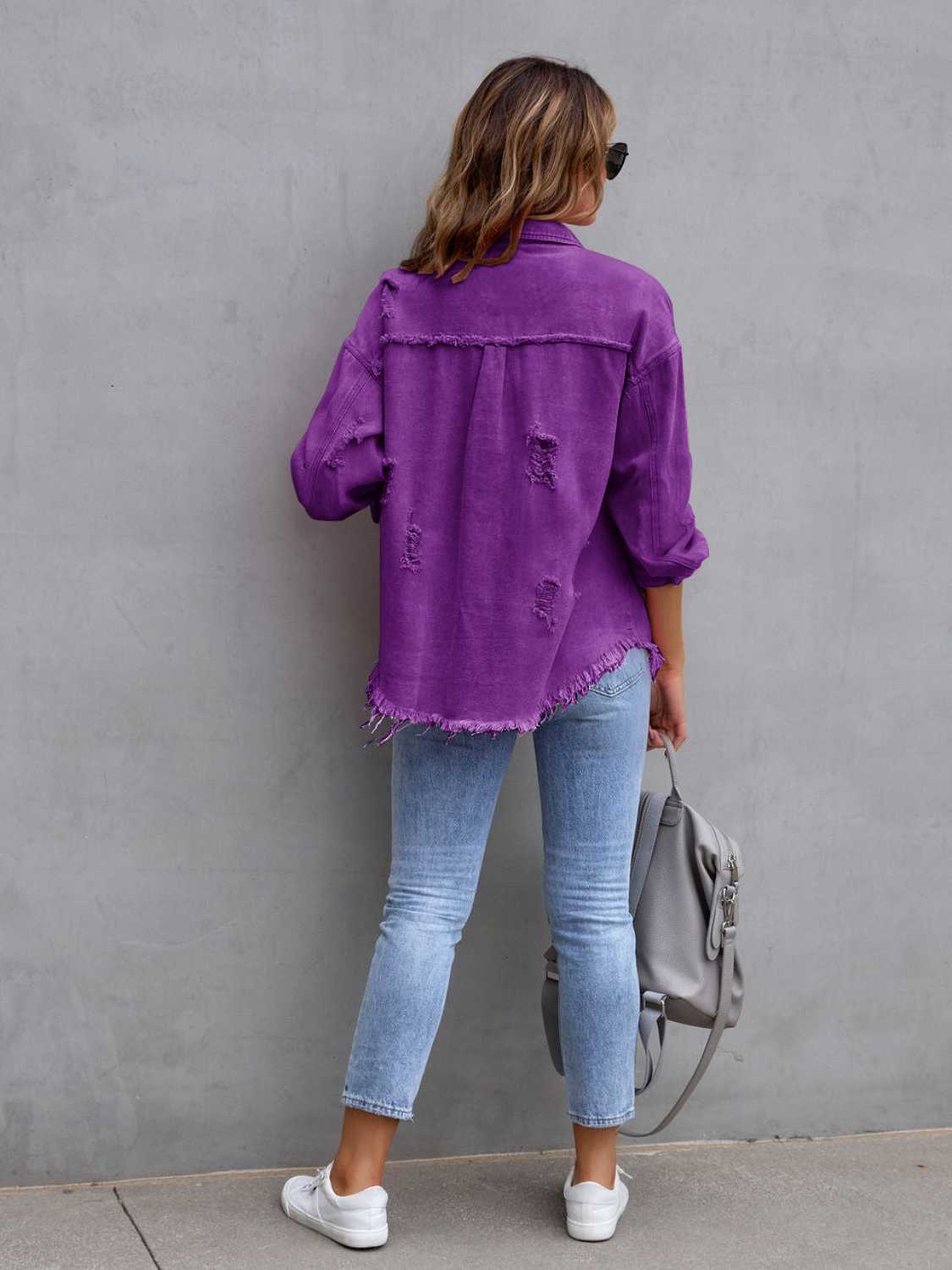 Back view of a purple distressed drop shoulder denim jacket with fringe hem and ripped details.