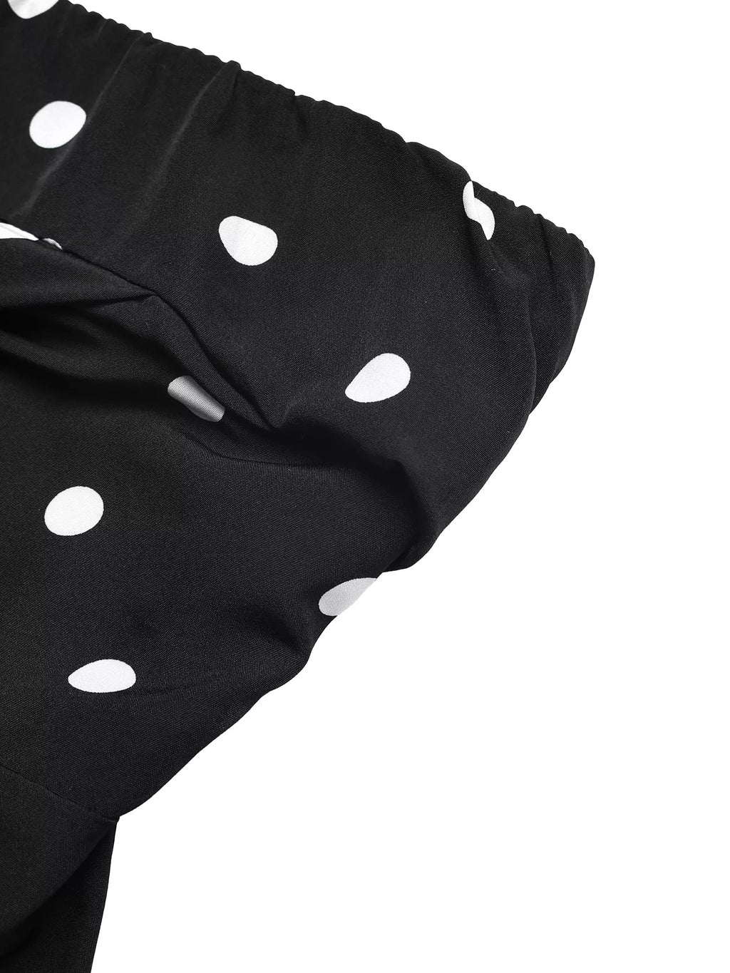 Close-up of black fabric with white polka dots on a strapless wide leg jumpsuit.