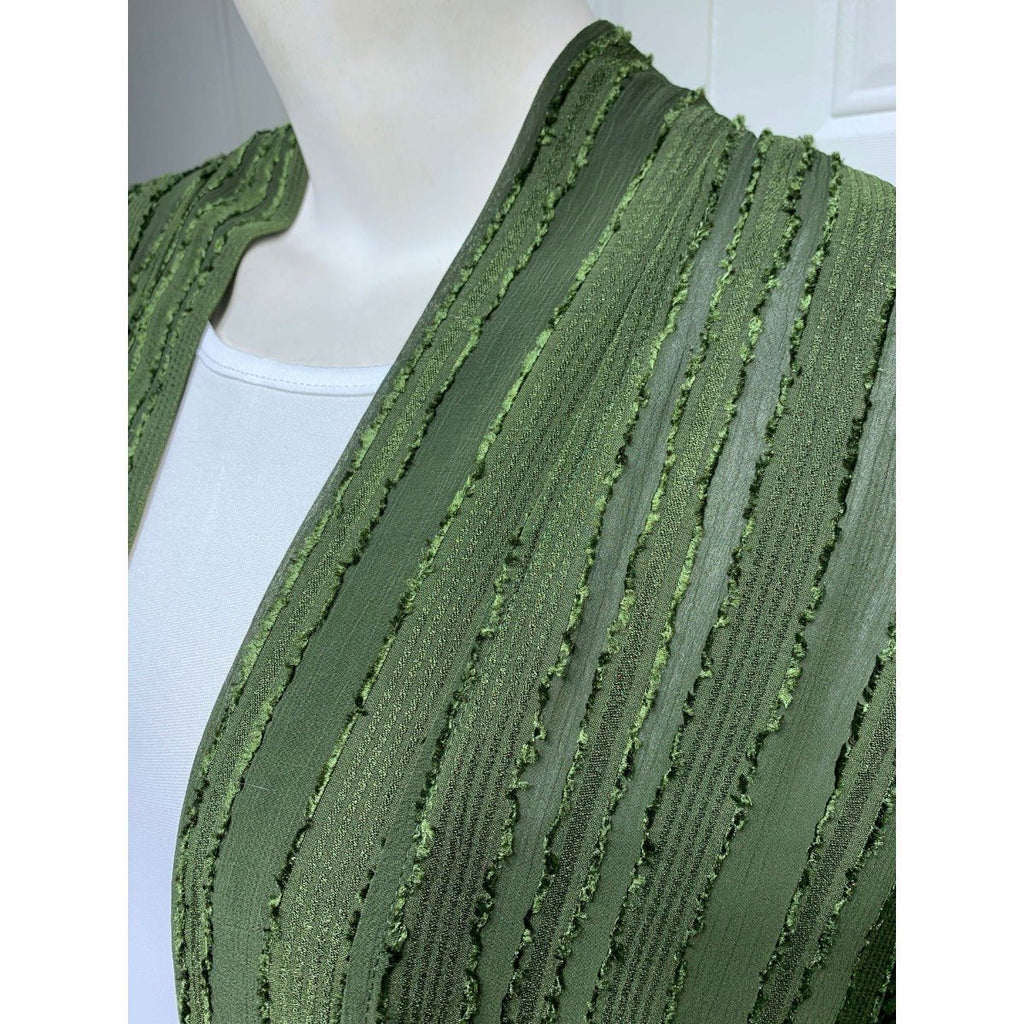 Close-up of a green vintage knitted cardigan abaya with vertical stripes and fringe details.