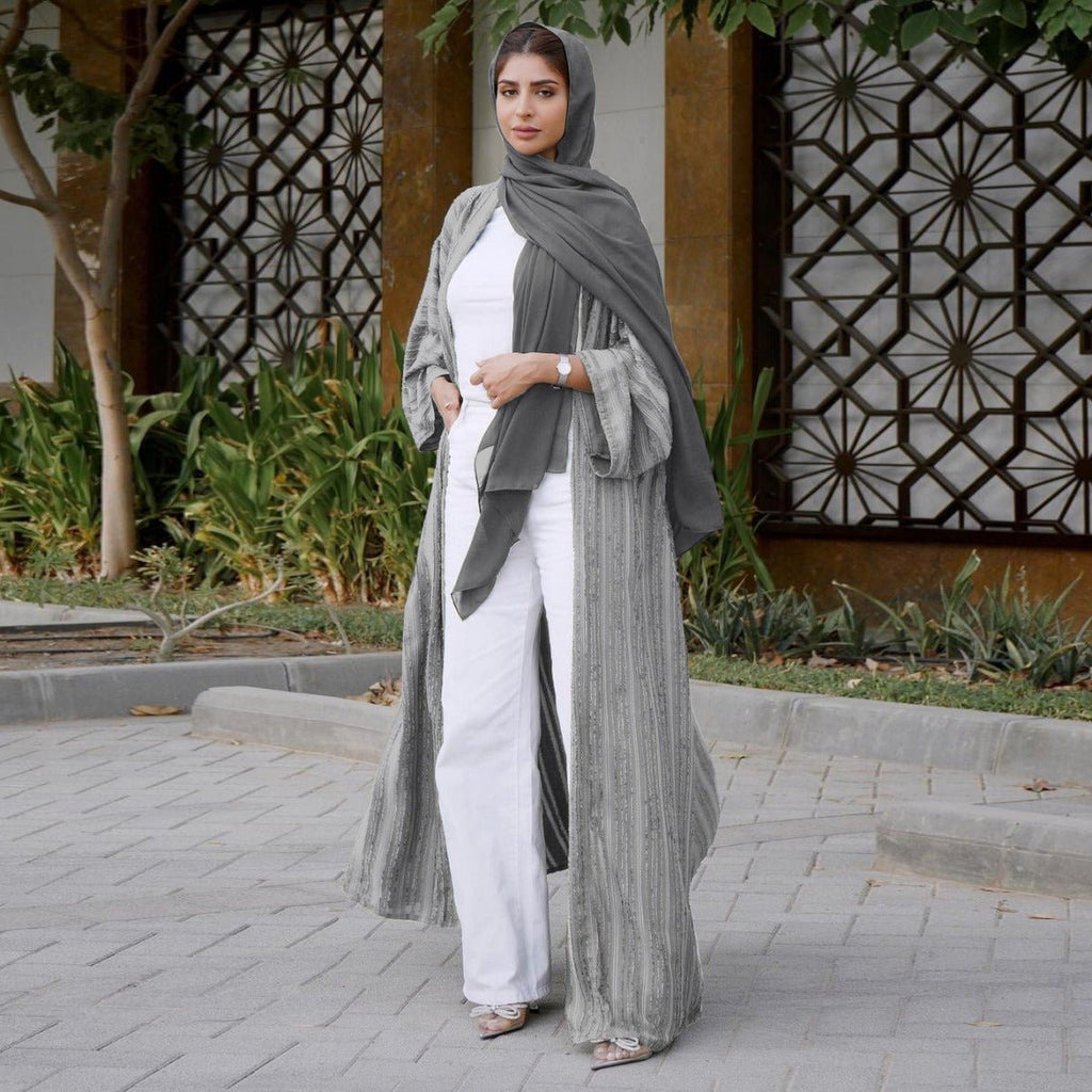 Woman wearing a grey vintage knitted longline open front abaya with vertical stripes and fringe.