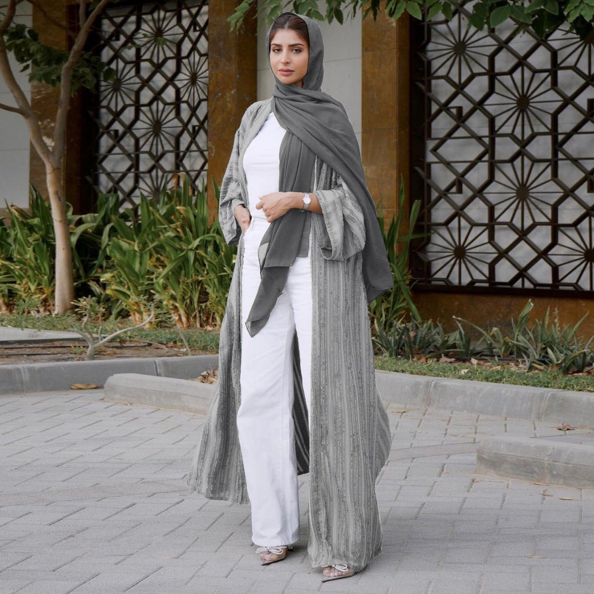 Woman wearing a grey vintage knitted longline open front abaya with vertical stripes and fringe.
