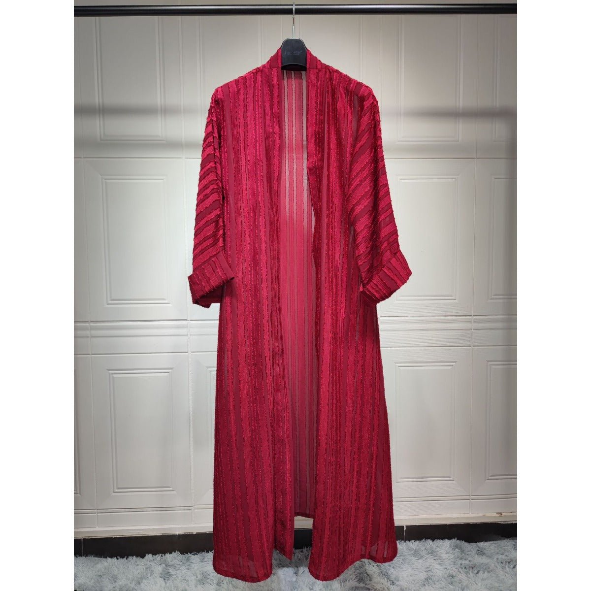 Red longline open-front knitted cardigan abaya with vertical stripes and fringe details.