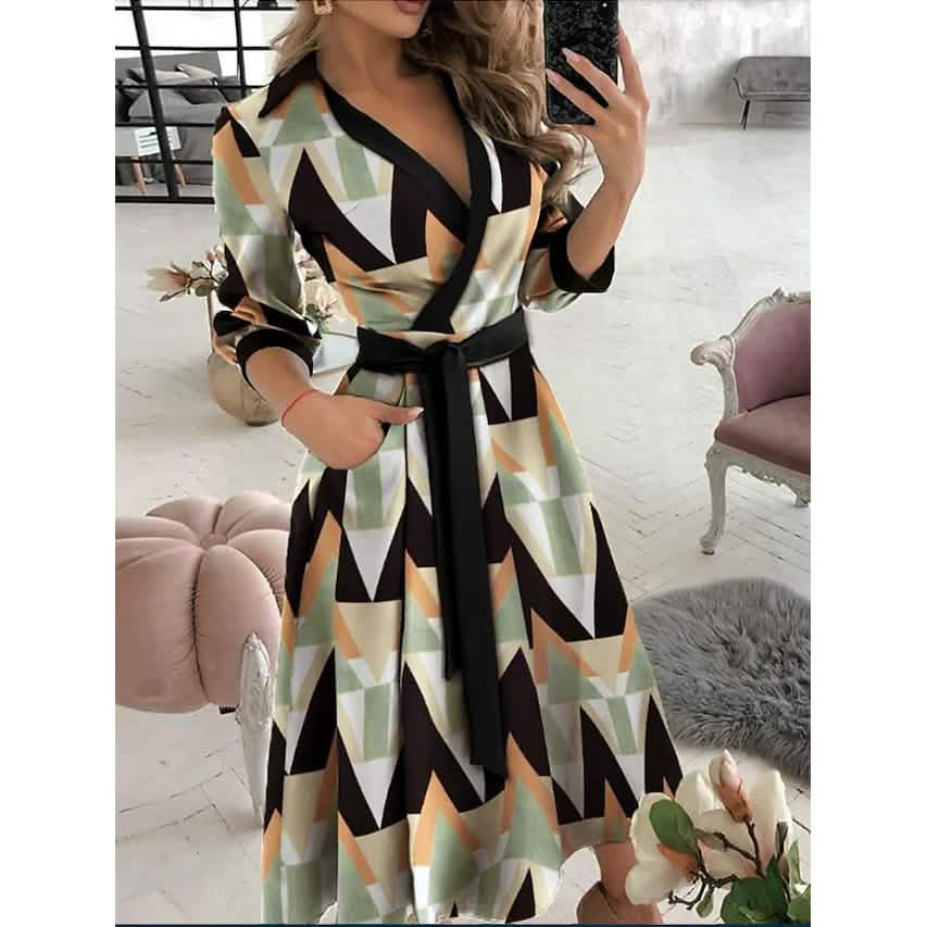 Woman wearing a geometric print A-line midi dress with a black belt and V-neck.