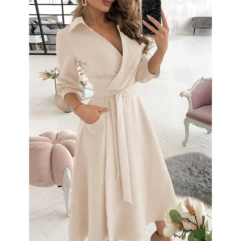 Woman in a cream A-line midi dress with a V-neck and tie waist.