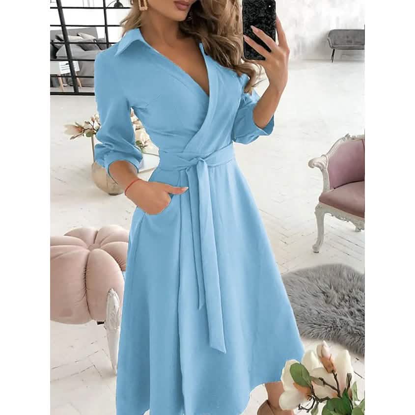 Light blue A-line midi dress with V-neck, tie waist, and 3/4 sleeves.