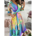 Woman wearing a tie-dye print A-line midi dress with V-neck and tie waist.