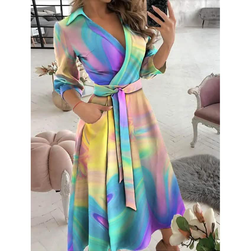 Woman wearing a tie-dye print A-line midi dress with V-neck and tie waist.
